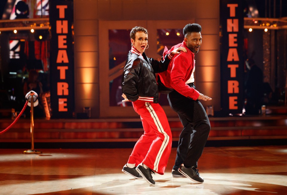 two men are dancing in front of a sign that says theatre