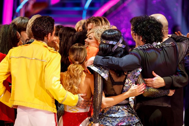 a group of people are hugging each other on a stage