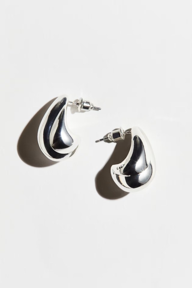 a pair of silver hoop earrings on a white surface