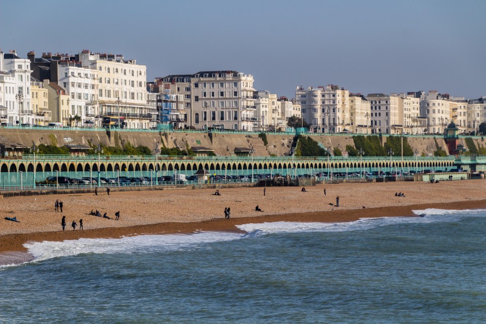 a beach with a row of buildings in the background