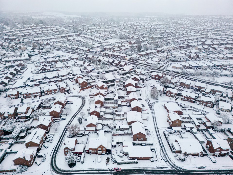 an aerial view of a residential area covered in snow