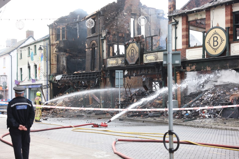 Police and firefighters look on at the devastation