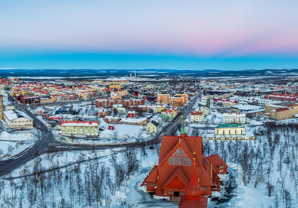 an aerial view of a snowy city with a church in the foreground