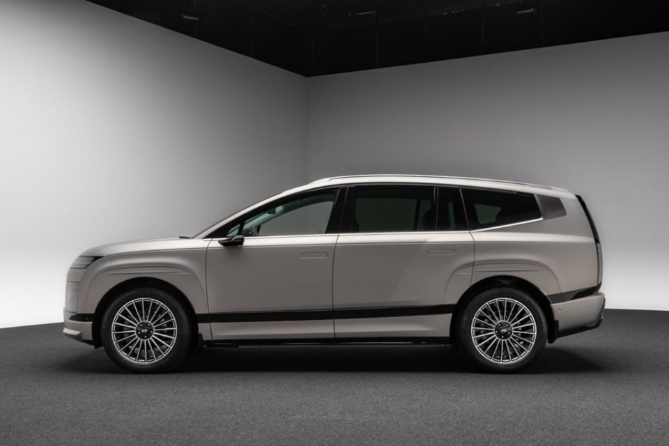 a white suv is parked in a room with a black ceiling