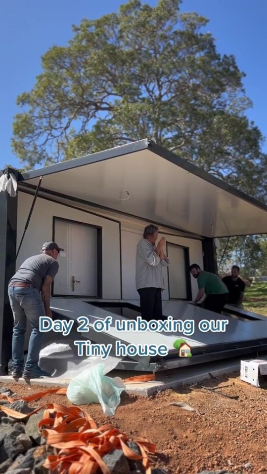 a group of people are unboxing a tiny house