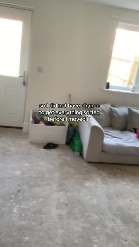 a living room with a couch and a box of toys on the floor