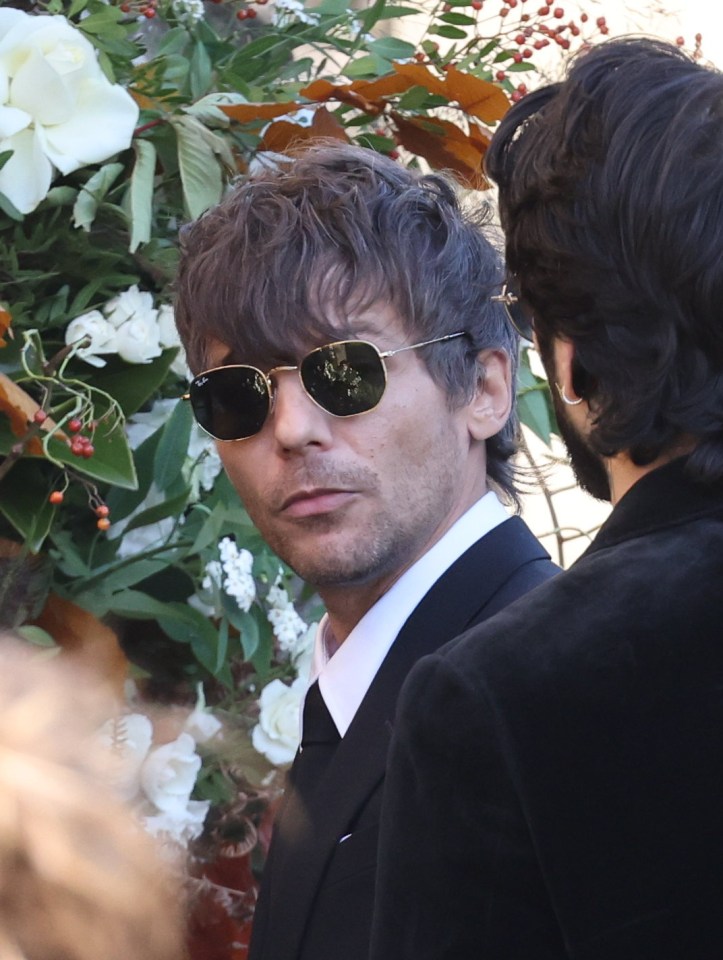 Louis Tomlinson pictured outside the church wearing black