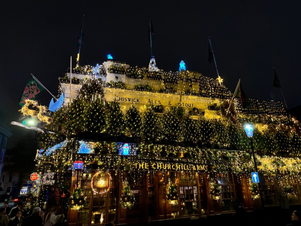 The Churchill Arms pub, decorated for Christmas with lights and greenery.