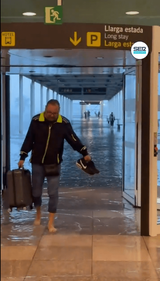 Passengers wading through water at the airport