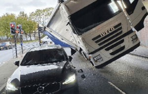 a white iveco truck crashed into a black car