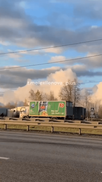 a green and white truck is driving down a highway