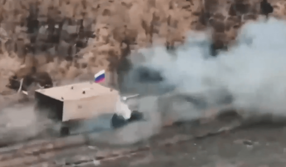 A ‘turtle tank’ with a Russian flag is seen ploughing through the battlefield