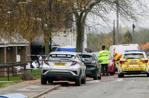 a group of police cars are parked on the side of the road .