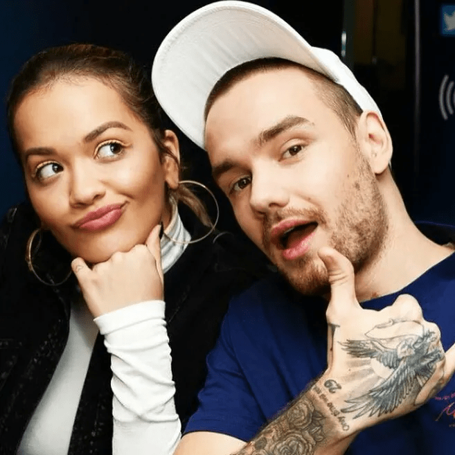 a man with a tattoo on his arm giving a thumbs up next to a woman