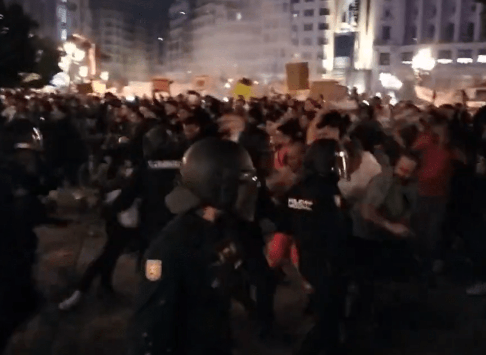 Tens of thousands of people marched through the streets of Valencia on Saturday as a brawl broke loose with police officers