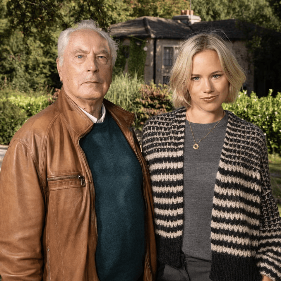 a man and a woman standing next to each other in front of a house