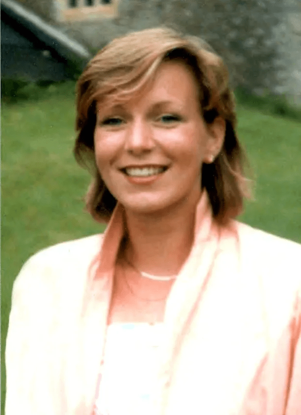 a woman in a pink jacket is smiling for the camera