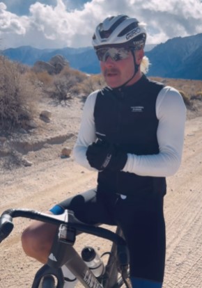 a man wearing a helmet and sunglasses is riding a bike