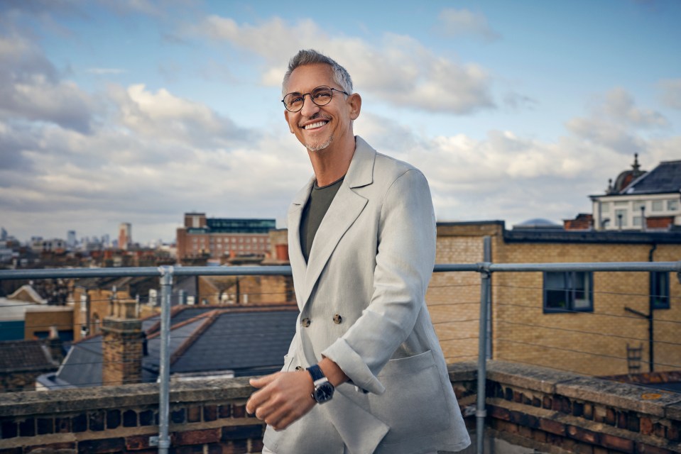 a man wearing glasses stands on a balcony overlooking a city