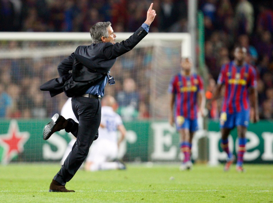 a man in a suit is running on a soccer field in front of a heineken sign