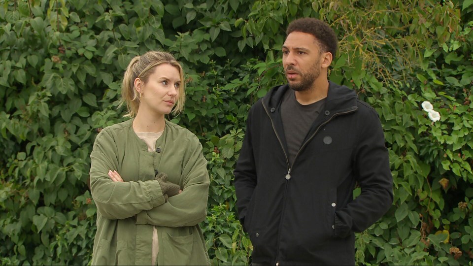 a man and a woman standing next to each other with their arms crossed