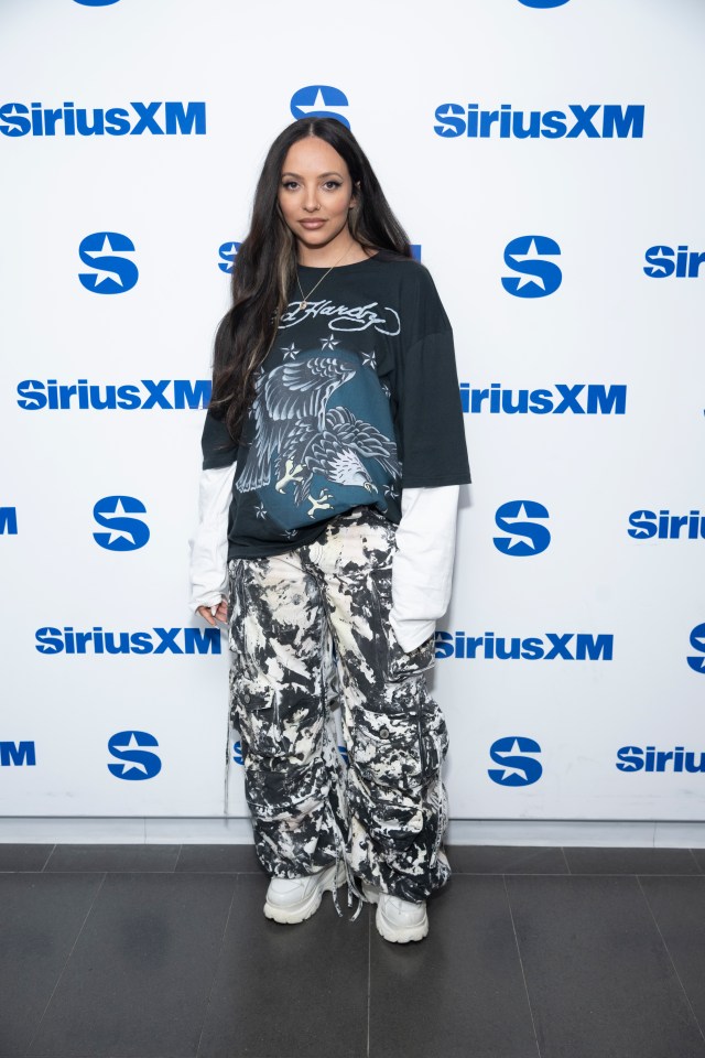 a woman stands in front of a siriusxm sign