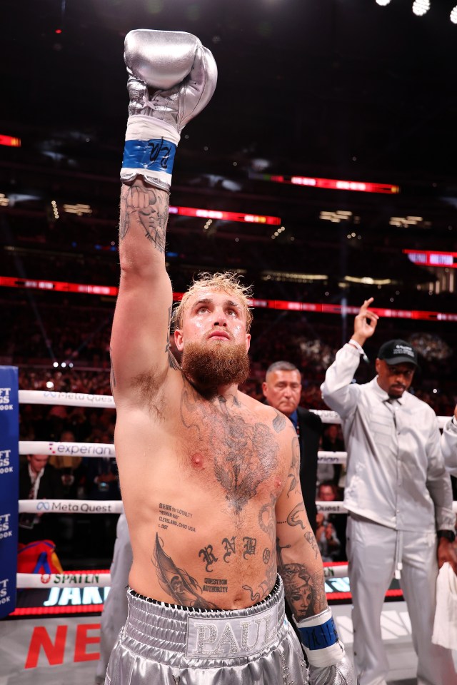 a boxer with a tattoo on his chest holds up his gloves