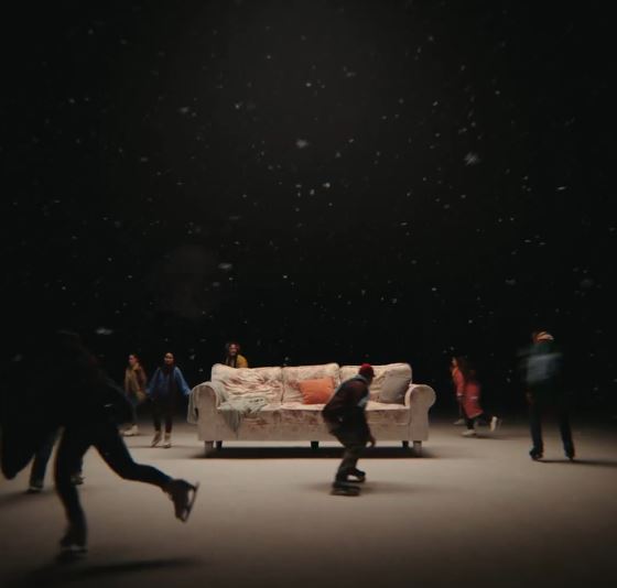 The 10-second clip shows ice skaters moving around a sofa in a darkened room