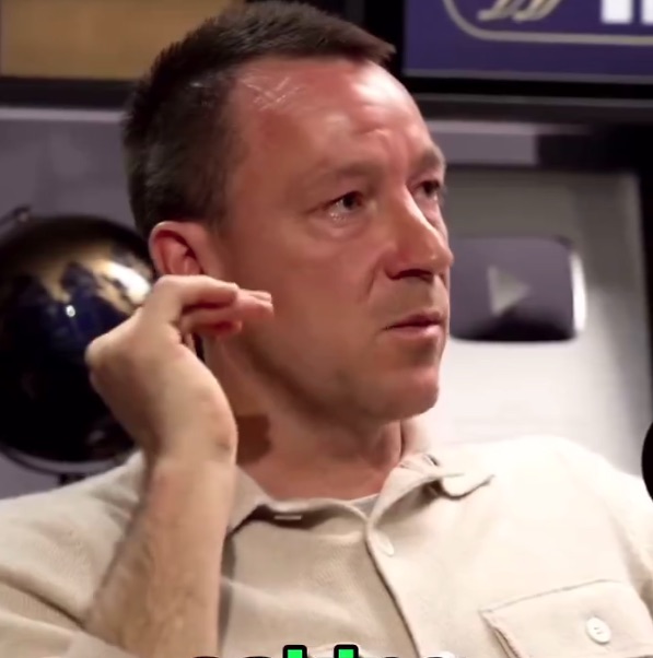 a man adjusts his ear while sitting in front of a globe