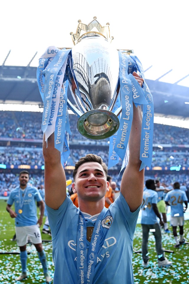 a man holding a trophy that says premier league on it