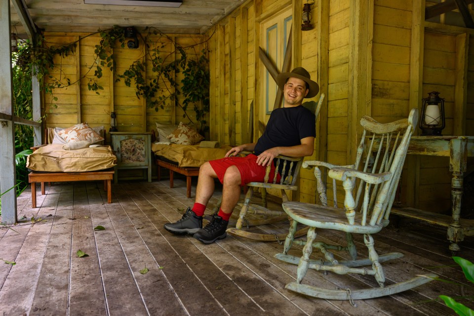 a man sits in a rocking chair on a porch