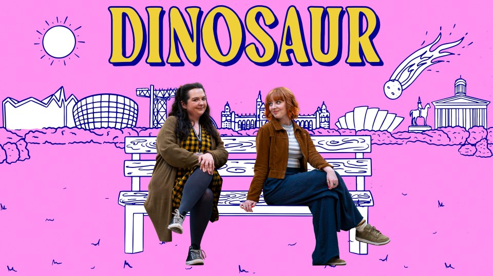 two women sit on a bench in front of a poster that says dinosaur