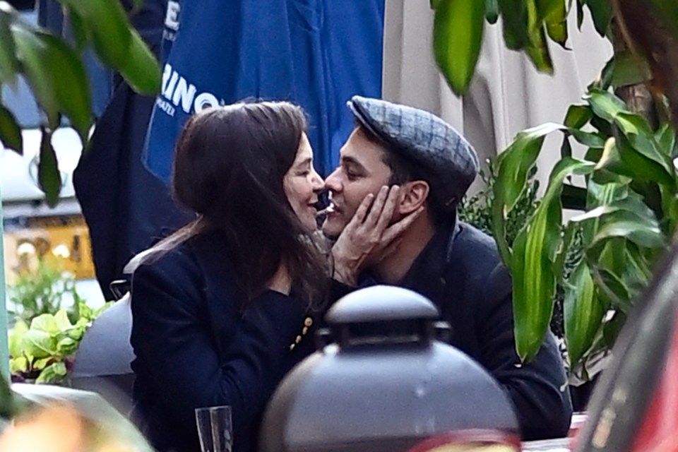 a man and woman are kissing in front of an umbrella that says king