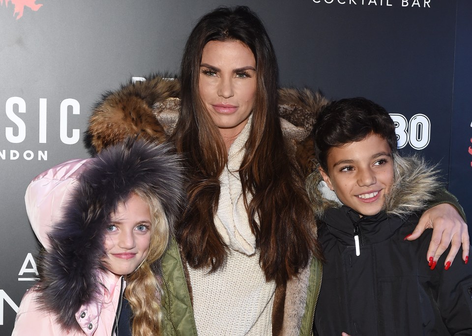 a woman and two children pose in front of a sign that says sic london