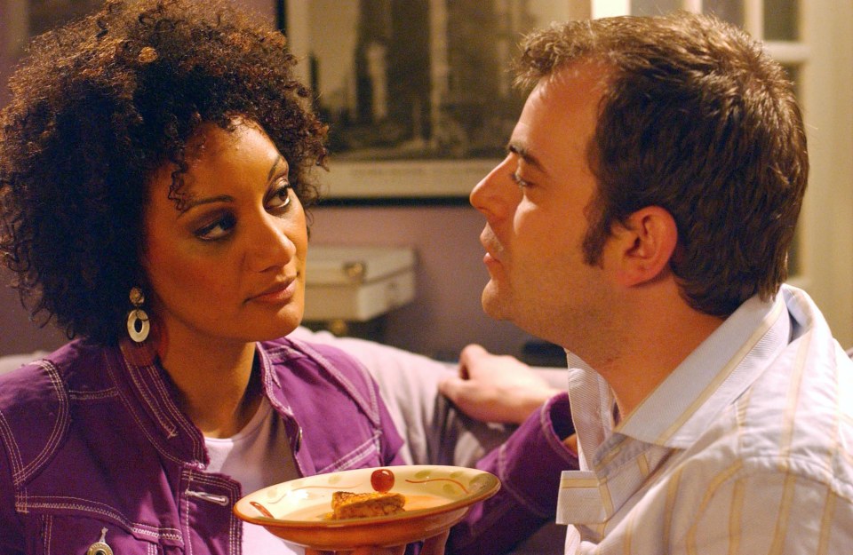 a man kisses a woman on the cheek while she holds a plate of food