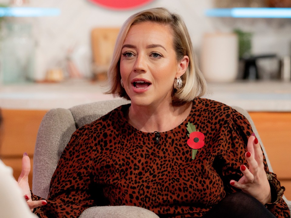 a woman in a leopard print dress has a poppy pin on her chest