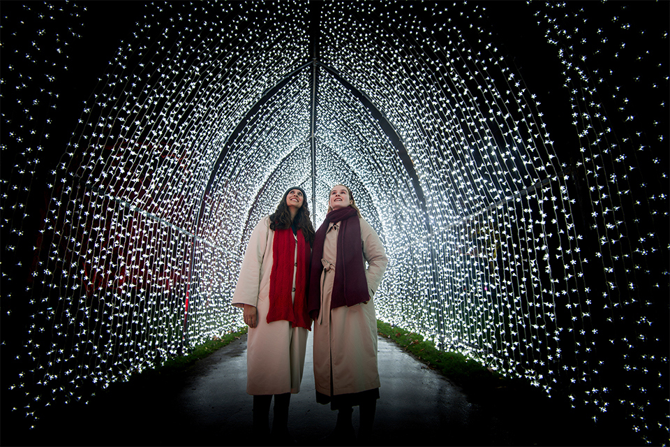 two women are standing in a tunnel of lights