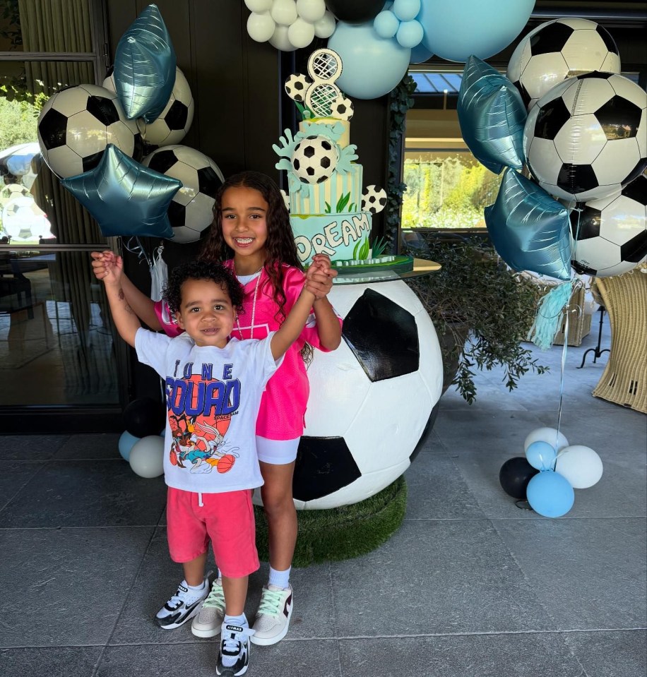 two children standing in front of a cake that says dream