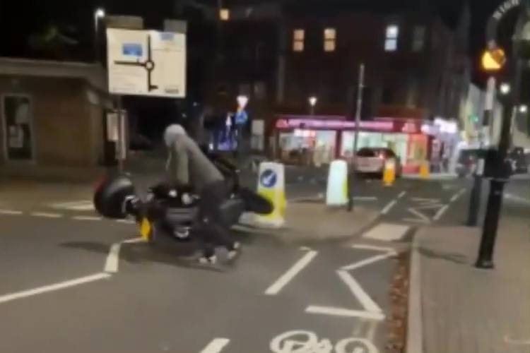 Shocking footage shows a man trying to manoeuvre a parked moped