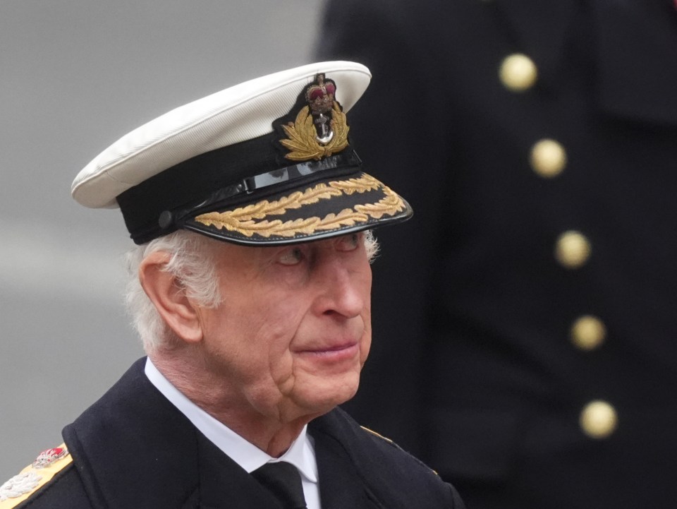 a man in a military uniform has the word navy on his hat