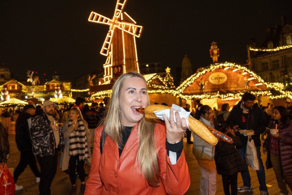 Kristina from Hereford eats a half-a-meter long Bratwurst sausage costing £9 at Birmingham’s Frankfurt Christmas Market