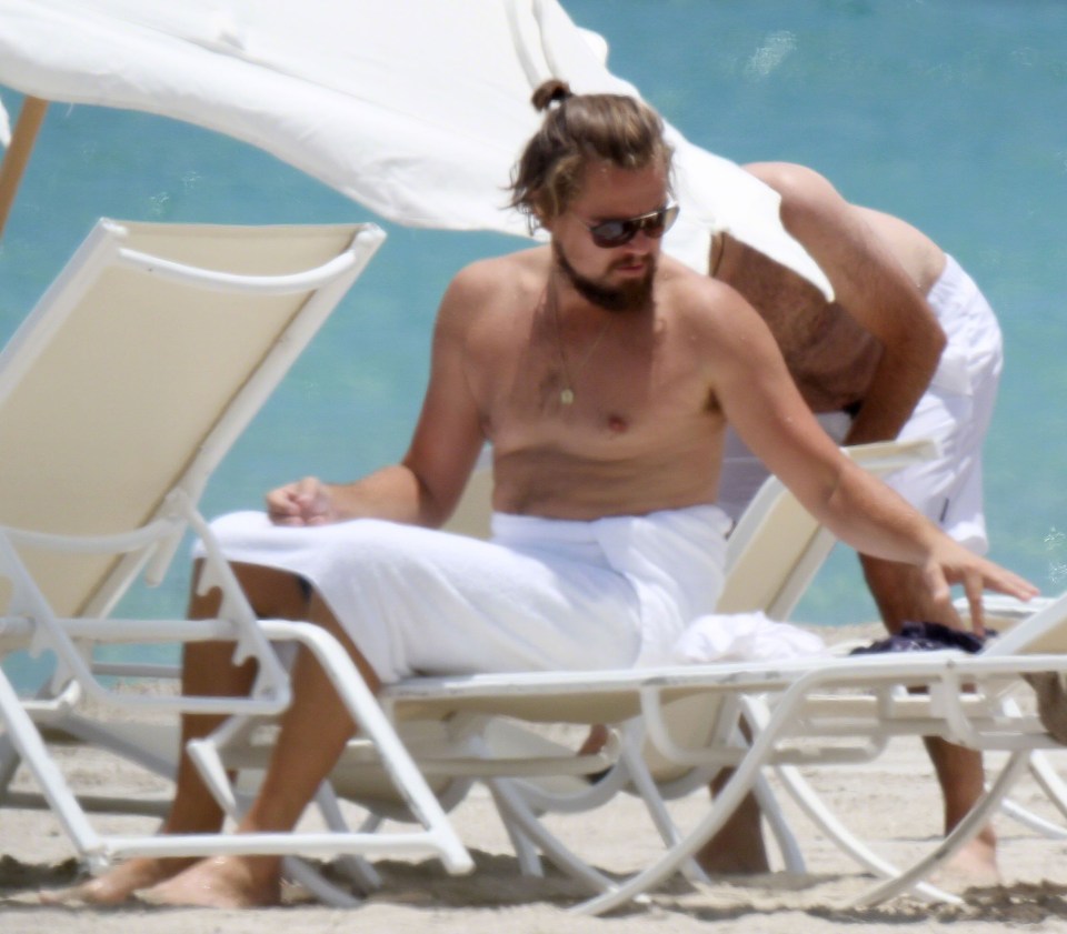 Leo sporting a new look with long hair and beard, shirtless in a beach in Miami