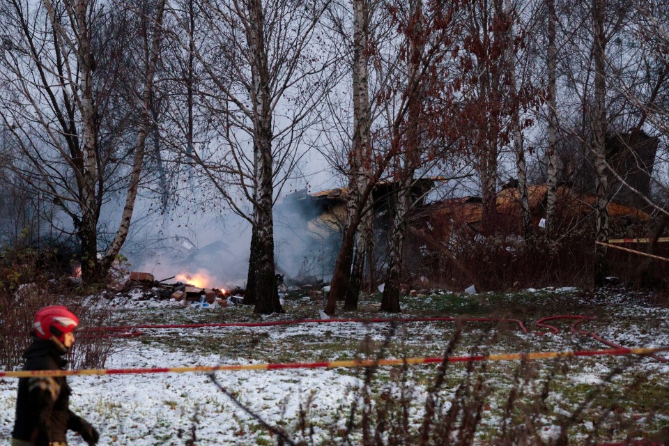 A rescuer walks past the wreckage of the cargo plane following the crash