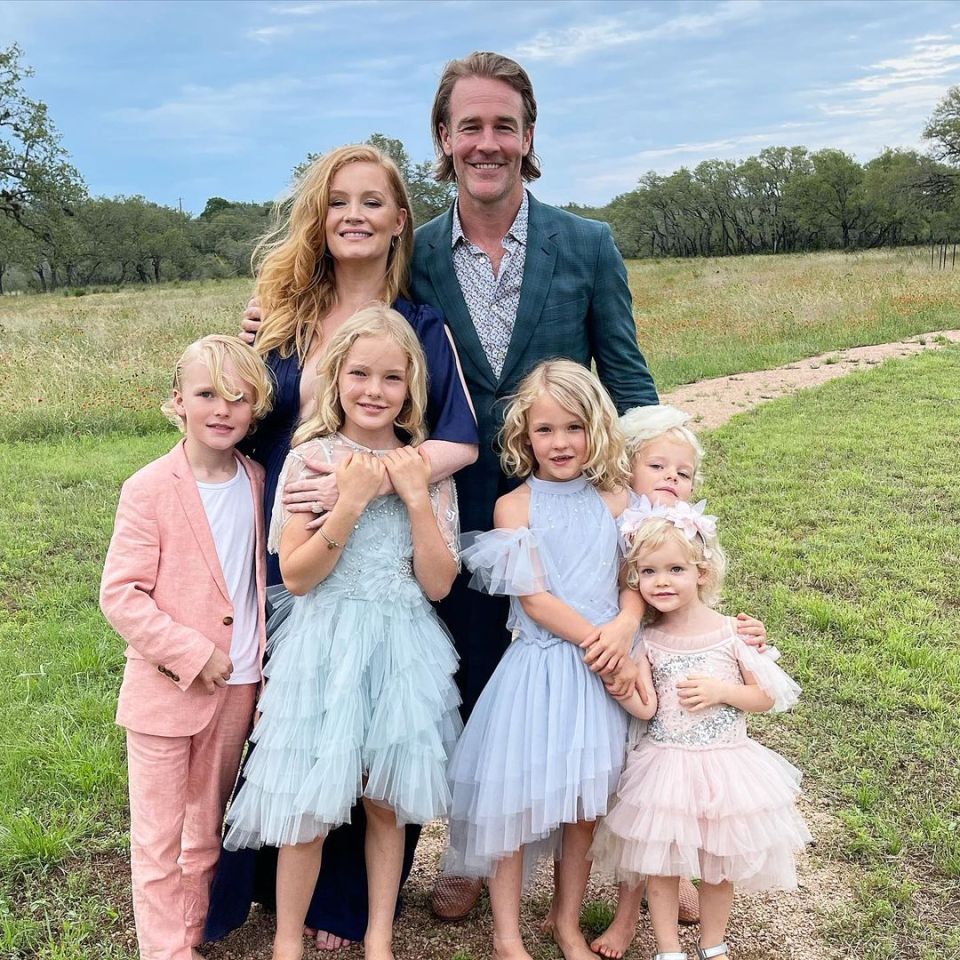 a family posing for a picture in a grassy field