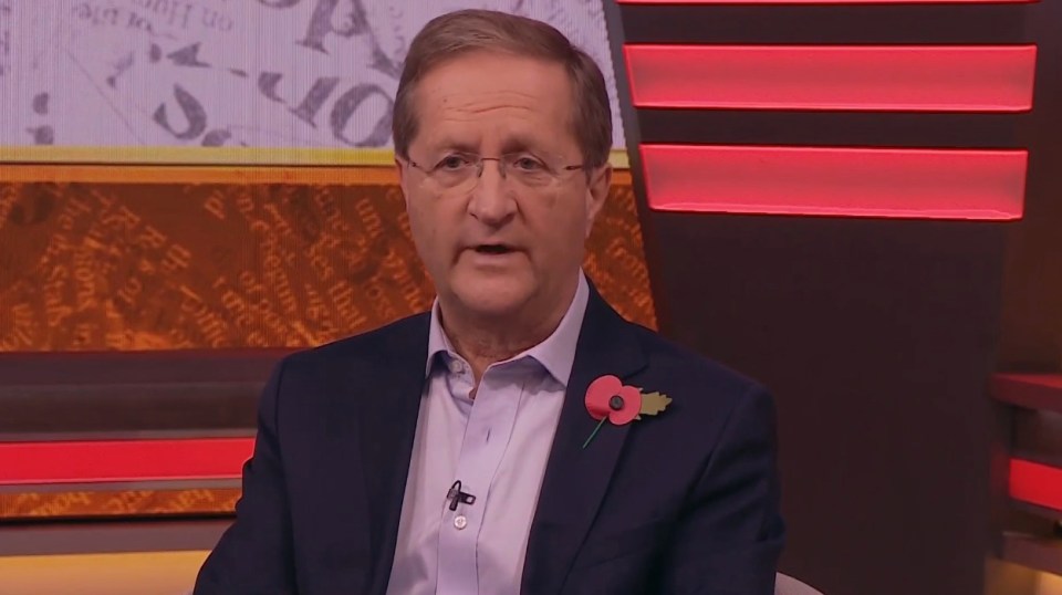 a man in a suit has a poppy pin on his lapel