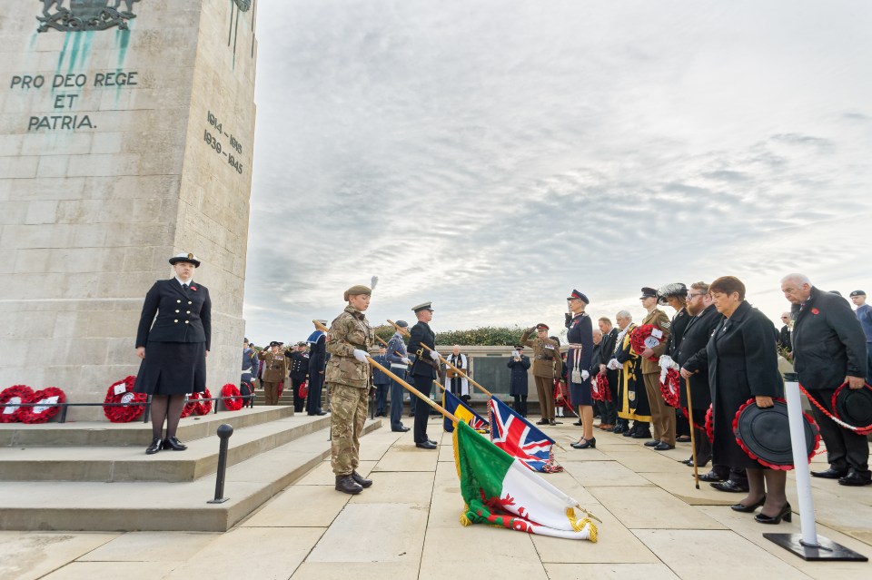 Flags are lowered by soldiers at the cenotaph in Swansea