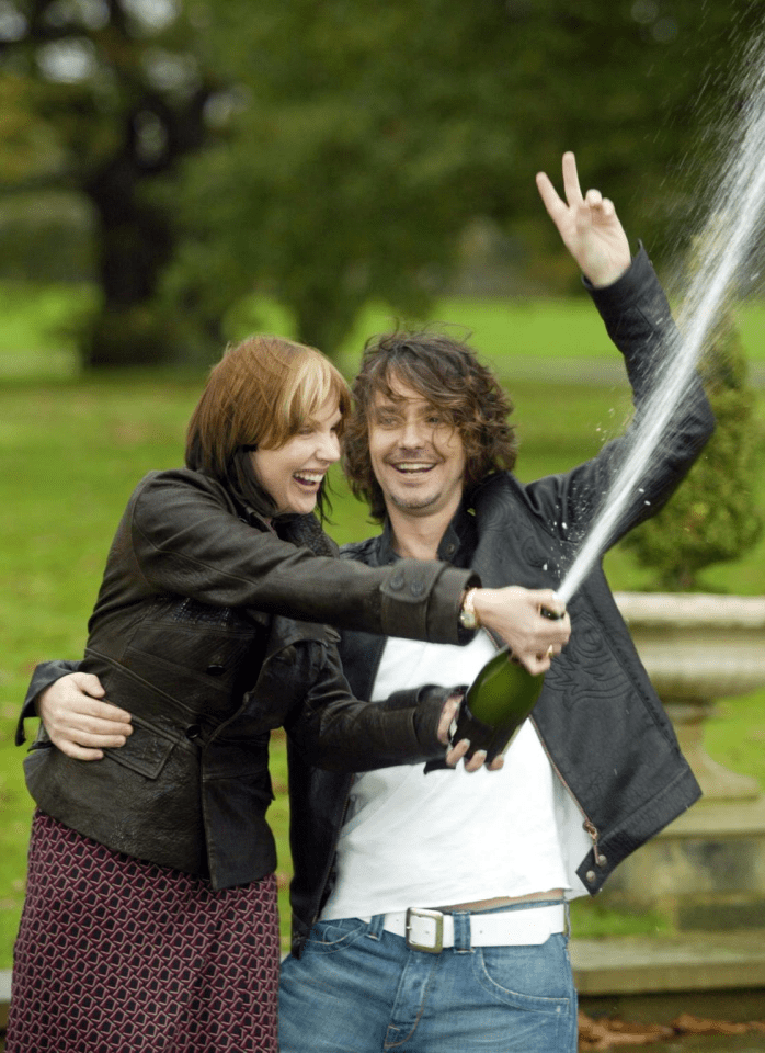 a man and woman are celebrating with a bottle of champagne