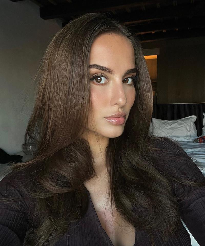 a woman with long brown hair is taking a selfie