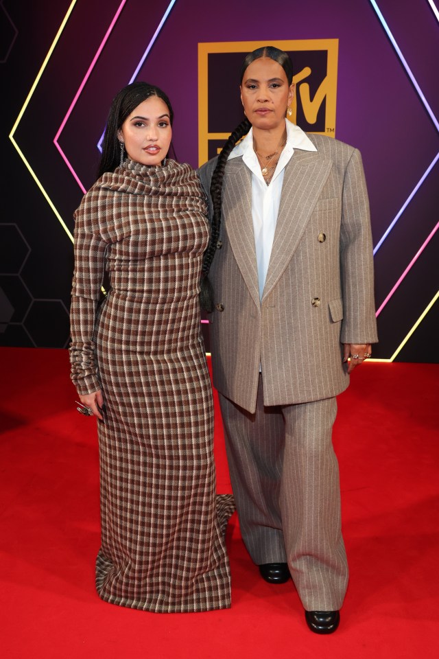 two women on a red carpet with a mtv logo in the background