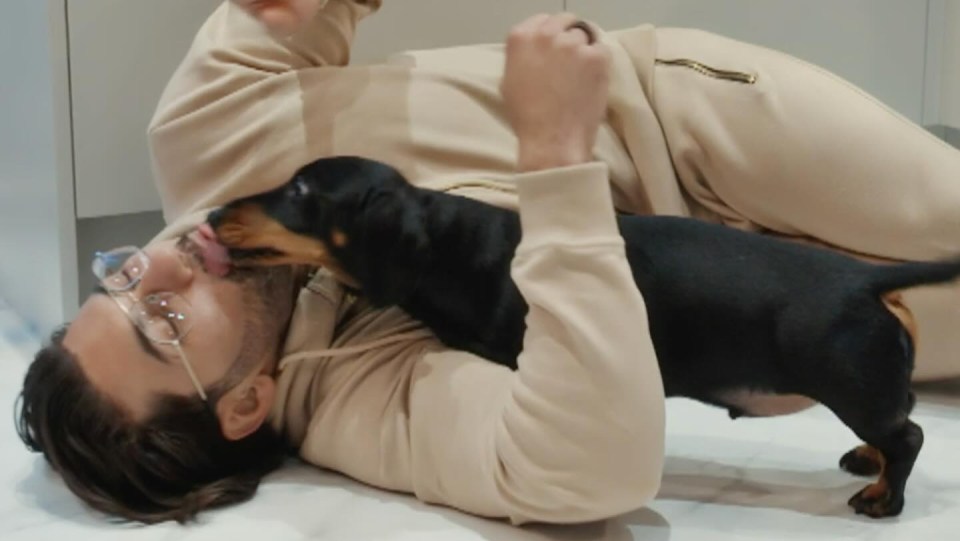 a man with glasses is laying on the floor with his dog